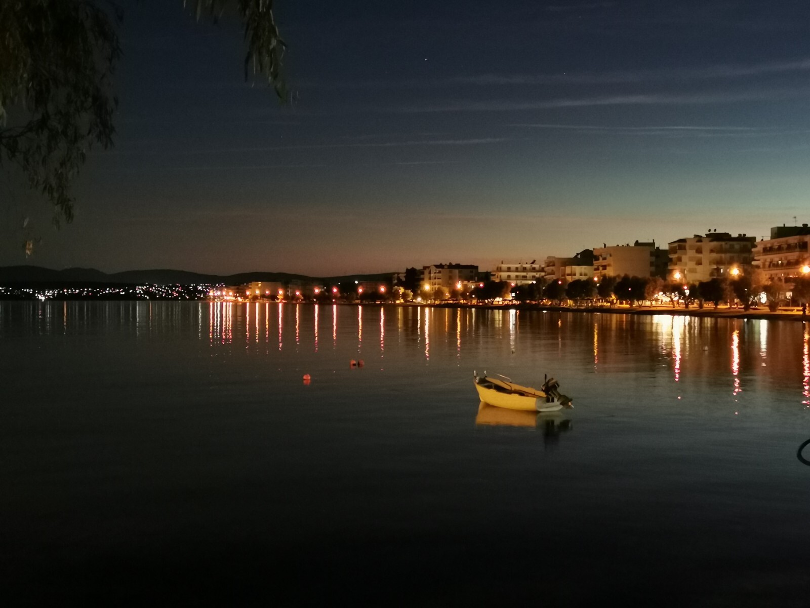 A calm town by the sea, behind a little boat
